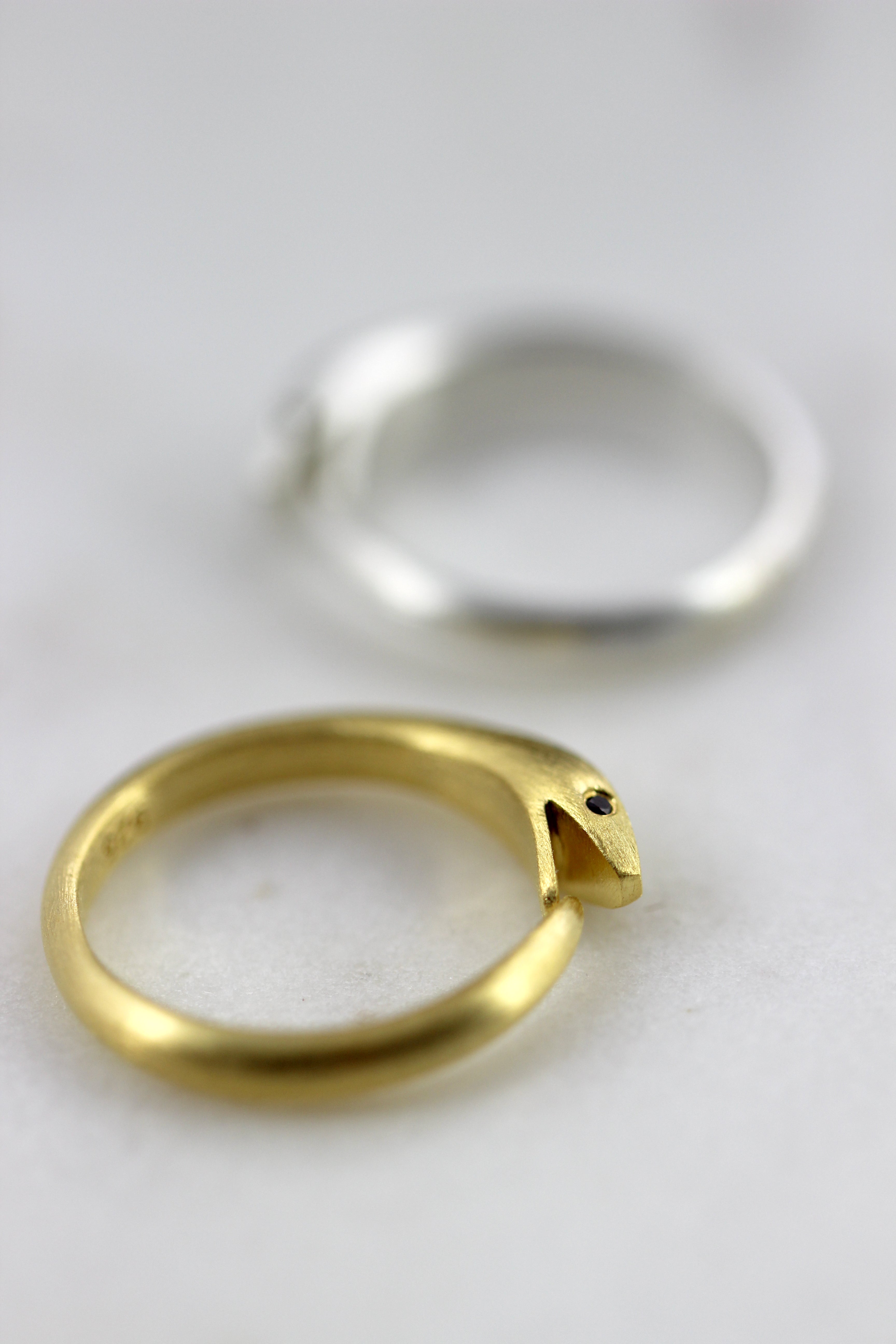 Photo of Sleek serpent ring in sterling silver with gemstone eyes, modern and symbolic.