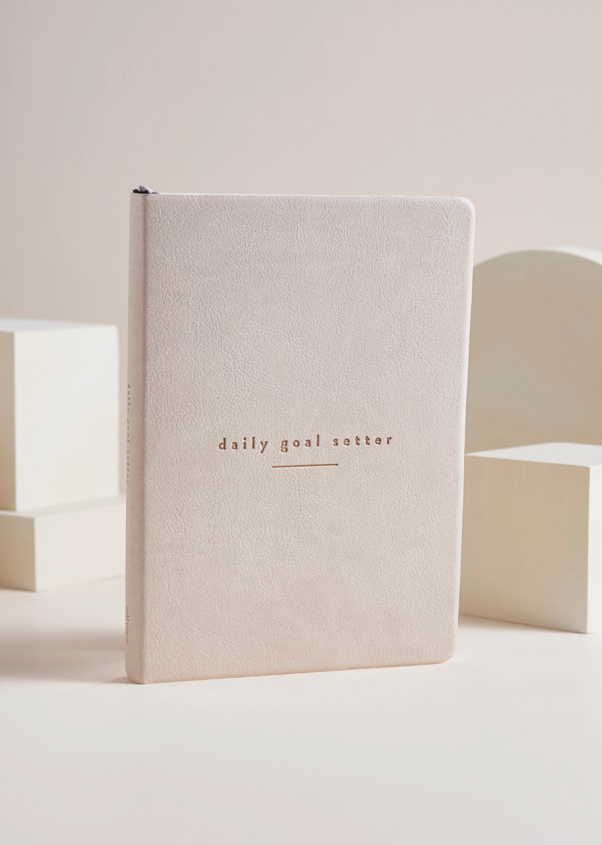 Photo of the tan minimalist daily planner with guided prompts for goal-setting and personal growth from Blackbird Designs.